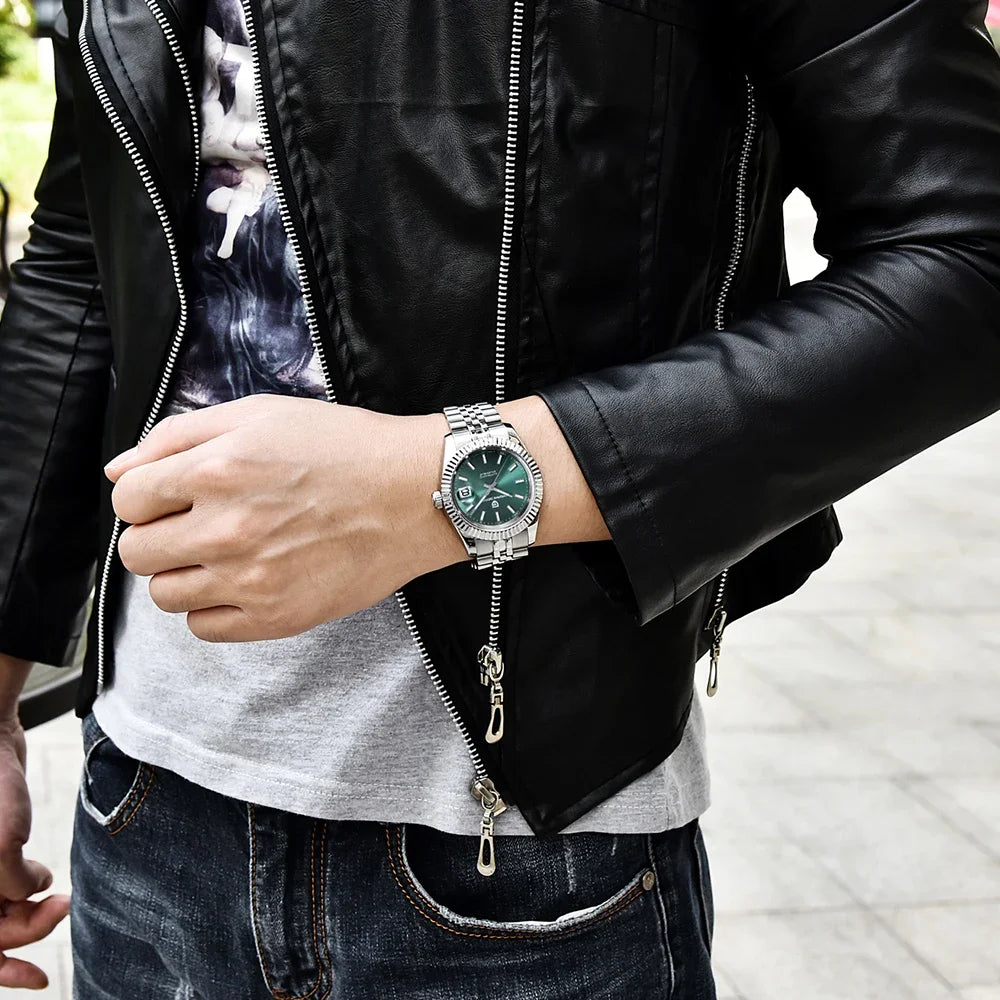 Person wearing green dial silver bracelet watch with leather jacket
