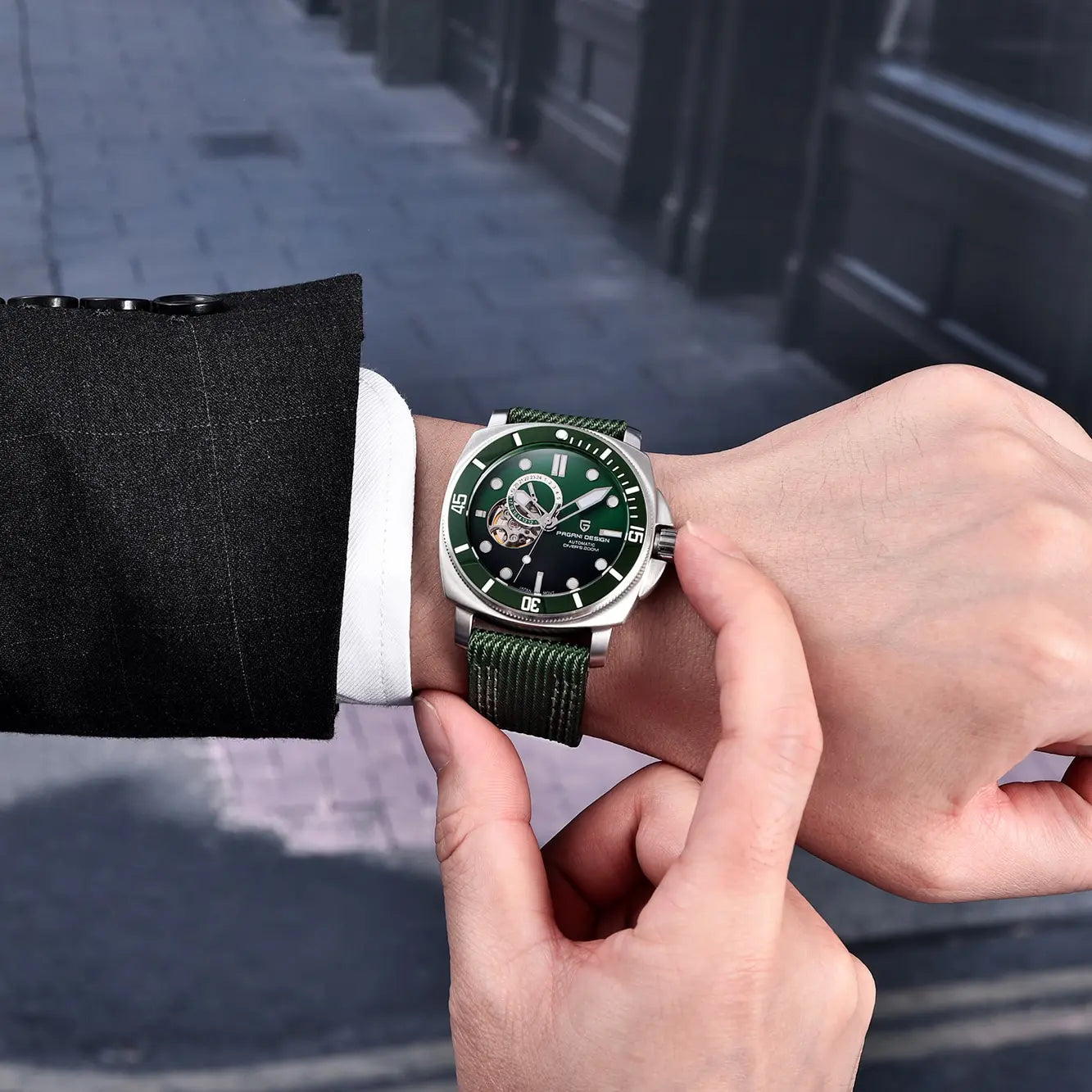 Person in suit adjusting green dial wristwatch