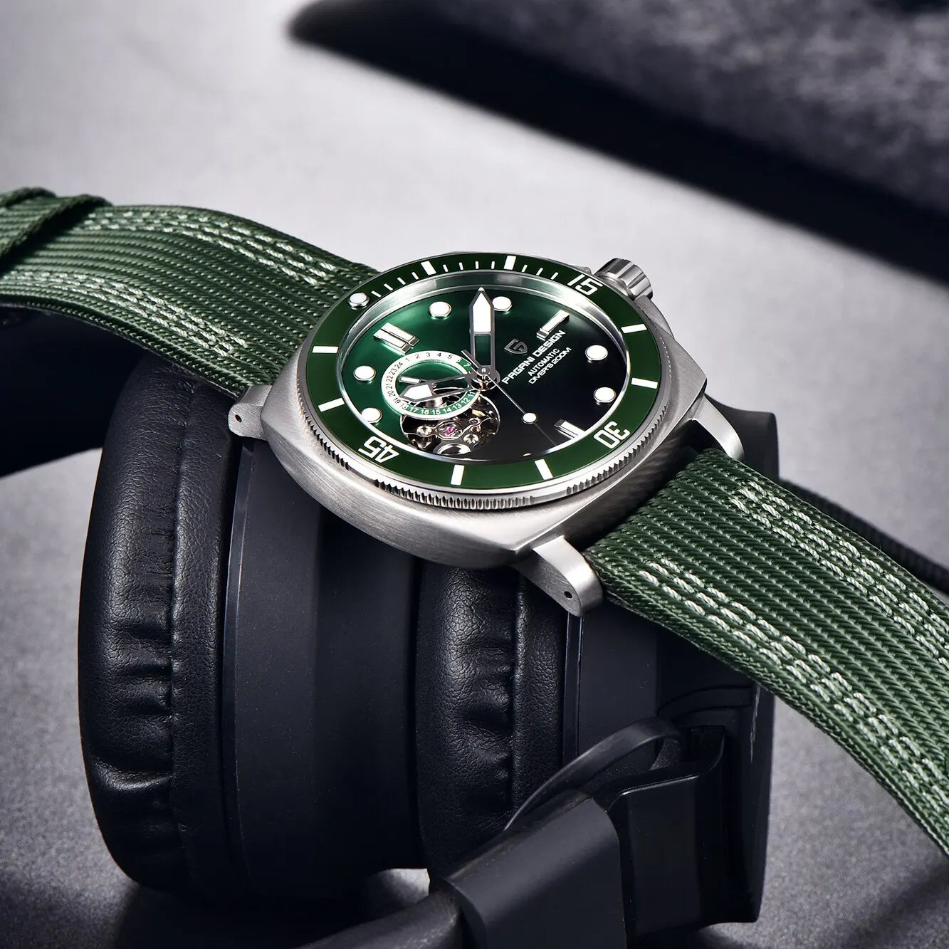 Green dial wristwatch resting on headphones